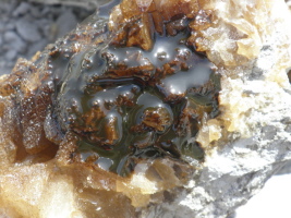 Erd&ouml;l in einem Hohlraum von Calcit